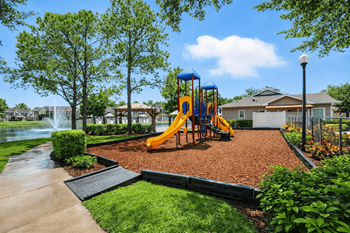 A playground with a yellow slide and a blue swing set.